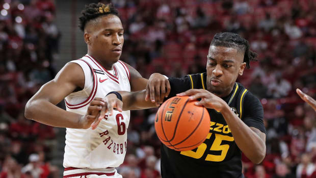 Feb 24, 2024; Fayetteville, Arkansas, USA; Missouri Tigers guard Sean East II (55) drives against Arkansas Razorbacks guard Layden Blocker (6) during the first half at Bud Walton Arena
